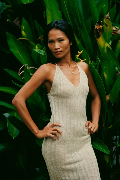 Cesur duruş ve nötr tonlar, bu tropikal moda esinlenilmiş sahnede canlı yeşillikle tezat oluşturuyor.