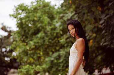 Açık yeşil bir ortamda güzelliği ve düşünceliliği harmanlayan etkileyici bir portre.