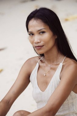 Yumuşak ışık ve beyaz kumla çerçevelenmiş özgüvenin ve iç huzurun ifadesi