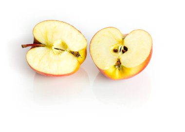 Sağlıklı bir elmanın iki yarısı, beyaz arka planda yansımalarla izole edilmiş. Kahvaltı için lezzetli meyve. Eko meyvelerinde vitamin var. Eko çiftliğinden gelen organik elmalar beyaz arka planda izole edilmiş. Kapat. Sağlıklı organik gıda konsepti.