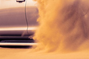 Namib çölünde kumda sıkışmış altın bir arabanın yakınında. Afrika