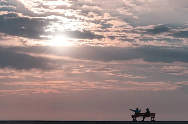 Duas Pessoas Sentadas Banco Rua Assistindo Belo Pôr Sol Dramático — Fotografia de Stock