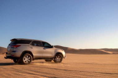Toyota Fortuner, güneşli bir günde Namib Çölü 'nün ortasında duruyor. 24.07.2021. Namibya, Afrika 