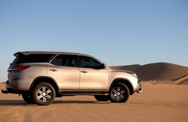 Toyota Fortuner, güneşli bir günde Namib Çölü 'nün ortasında duruyor. 24.07.2021. Namibya, Afrika 