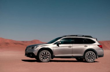 Güneşli bir günde Namib Çölü 'nün altın kumlarında gri bir araba duruyor. 29.08.2021. Sossusvlei, Namibya