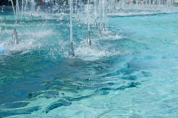 スプラッシュとフォームジェット水ストリーム効果のための滑らかなボアノズル。街の噴水のターコイズブルーの水面にリップルと反射。都市水機能産業. — ストック写真