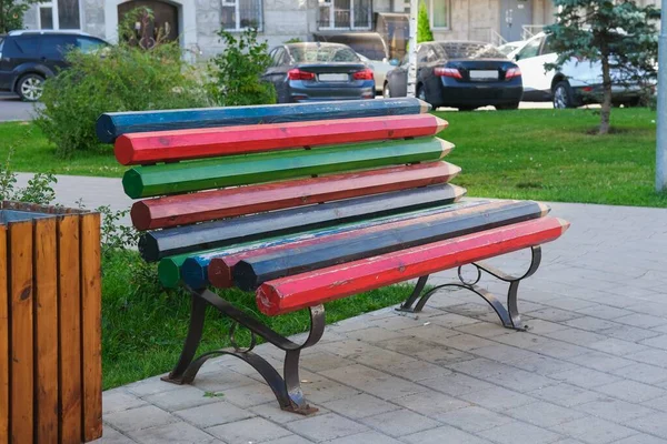 Mobília urbana moderna resistente da madeira da rua. Banco de madeira multicolorido criativo feito das placas estilizadas como lápis de cor no campo de jogos das crianças no parque público. — Fotografia de Stock