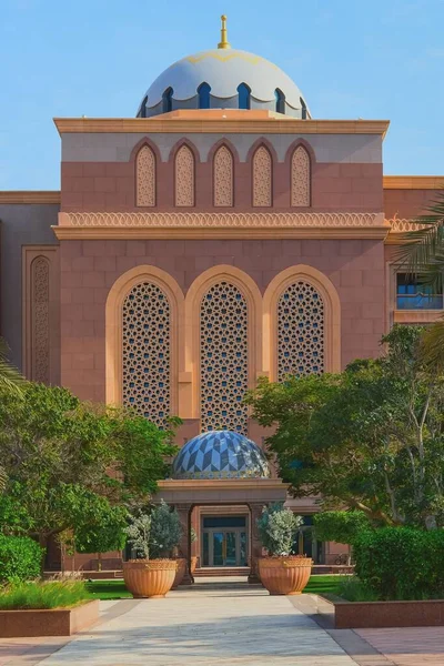 Abu Dhabi, Emiratos Árabes Unidos, marzo de 2021.Vista frontal a uno de los arcos ornamentados tradicionales de entrada de diseño de estilo árabe con tallado artesanalmente en la pared de mármol en el lujoso Palacio Presidencial de los Emiratos desde el lado del patio — Foto de Stock