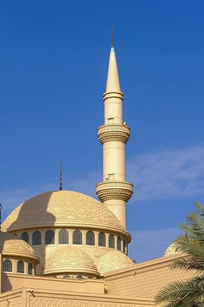 Minaret and dome of Muslim islamic mosque on background of blue sky. Minaret tower and roof cupola with traditional crescent, archtectural decorative elements. — Stock Photo, Image