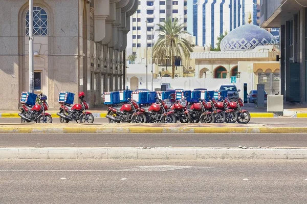 Food delivery service in UAE. Group of motorcycles parked on special parking on the street waiting for the order and delivery to the customers. — Stock Photo, Image