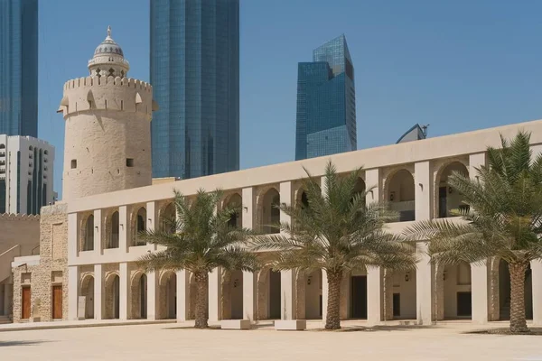 Binnenplaats met gewelfde arcade, palmbomen en wachttoren van Qasr al-Hosn fort museum, het oudste stenen gebouw in Abu Dhabi, Verenigde Arabische Emiraten — Stockfoto