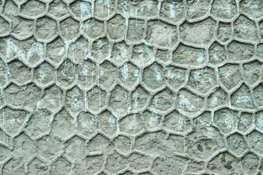 Weathered plaster wall with deep cracks and historic geometric ornament resembling fish scales or honeycomb. Captured in Leh, Ladakh, signature style of traditional Himalayan homes