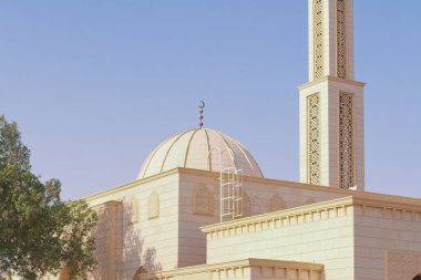 Dekoratif İslami kemer ve cami cephesinde geometrik şekilli kubbe. Sıcak güneş ışığında geleneksel Orta Doğu mimarisi