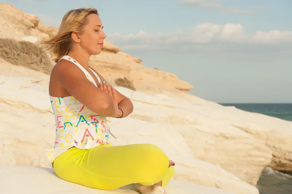 Mujer joven está meditando junto al mar — Foto de Stock