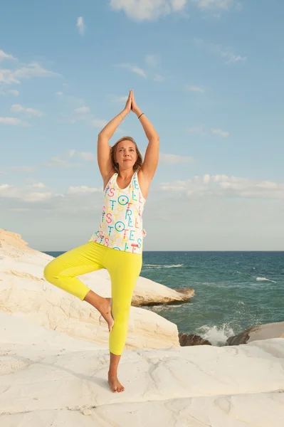 Mujeres jóvenes haciendo yoga junto al mar - pose de árbol (Vrikshasana ) — Foto de Stock