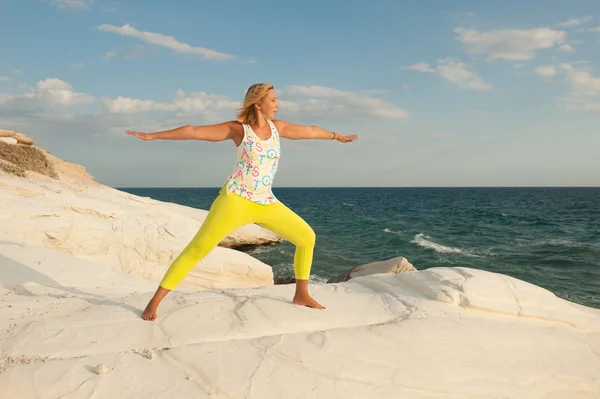 Genç kadın deniz - savaşçı yoga yaparken (Virabhadrasana poz)