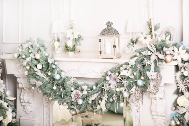 Şöminenin Noel süslemesi ve oda köknar dalları Yeni Yıl oyuncakları, fener ve mumlarla.