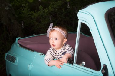 Arabada oturan ve pencereden dışarı bakan süpriz bir kız çocuğu. Komik küçük sürücü..