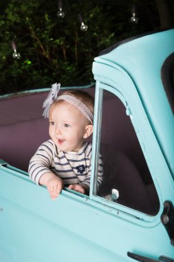 Arabada oturup pencereden dışarı bakan mutlu, gülümseyen bir kız. Tatilde eğlenceli bir gezi..