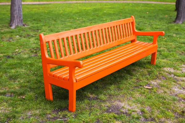 公園内の明るいオレンジの木のベンチ — ストック写真