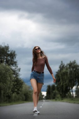 Yolun ortasında tek başına yürüyen genç bir kadın..