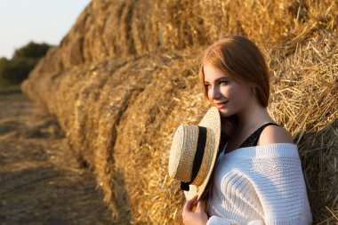 Saman arka planında şapkalı güzel mutlu bir kızın portresi..