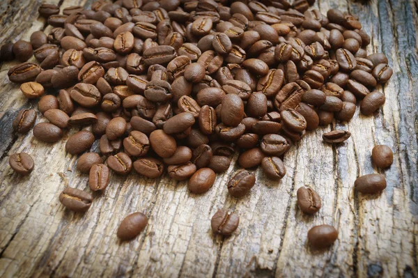 Koffiebonen op houten ondergrond — Stockfoto