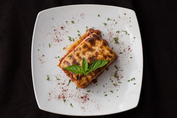 Lasagne op een plein wit bord — Stockfoto
