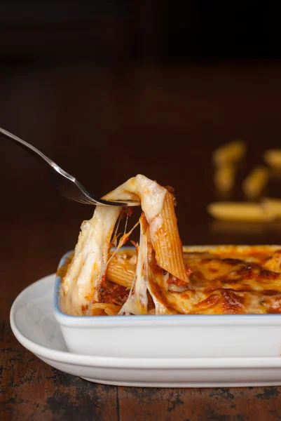 Zapečené penne těstoviny s rajčatovou omáčkou a sýrem — Stock fotografie