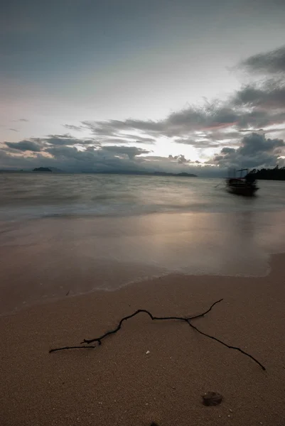 Båt på stranden vid soluppgången i tide tid. — Stockfoto