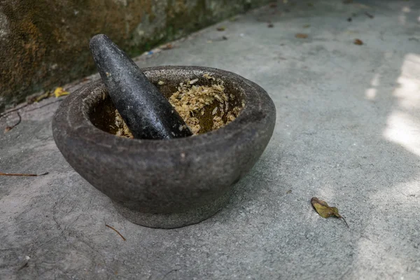 Ancien mortier de granit avec pilon et ail — Photo