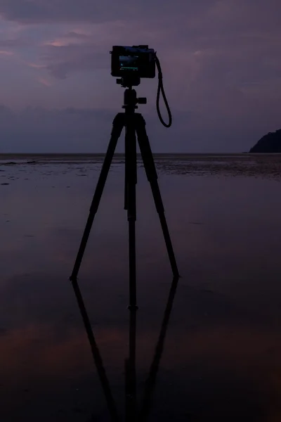 Camera on the beach with reflection in water during sunset. — Stock Photo, Image