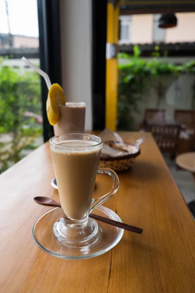 A cup of hot cappuccino with Chocolate banana smoothie and bread — Stock Photo, Image