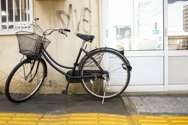 Bicycle against wall in japan — Stock Photo, Image