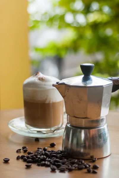 moka pot ve bir fincan kahve kavrulmuş kahve çekirdekleri ile