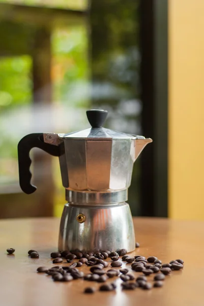 moka pot ve bir fincan kahve kavrulmuş kahve çekirdekleri ile