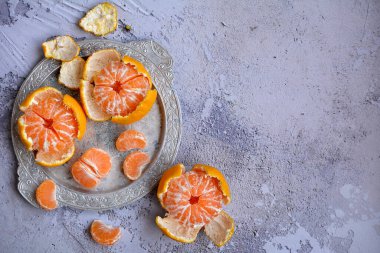 Servis tabağında kabuklu olgun, sulu mandalinaların en üst görüntüsü. Tasarım için yan alan. Mevsimlik Meyve Konsepti