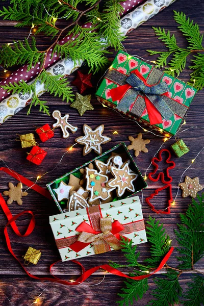 Vertical New Years composition with red gift box, Christmas cookies and decorations on a dark wooden background. — Stock Photo, Image