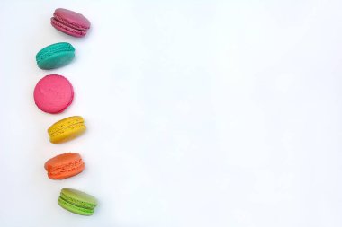 Fotokopi alanı olan beyaz bir zemin üzerinde çok renkli bir badem kurabiyesinin üst görüntüsü. Düz yatıyordu. Seçici odak