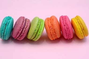 Pembe arka planda çok renkli makaronlar, yakın plan..