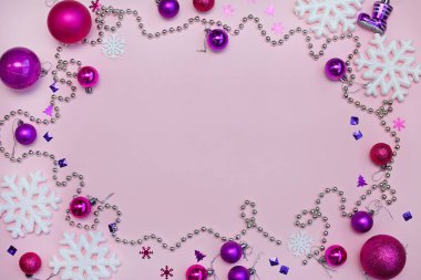 Mor Noel baloları, kar taneleri ve pembe bir zemin üzerinde fotokopi alanı olan boncuklar. Üst görünüm