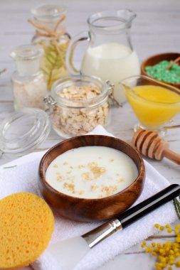 Parlak bir arka planda dikey kompozisyon. Yulaf ezmesi, süt, bal maskesi. Yakın çekim.