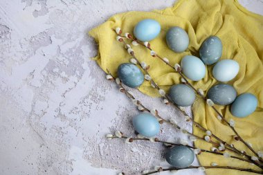 Gri arka planda Paskalya yerleşimi. Sarı peçetedeki mavi, mermer, gri yumurtalar. Düz yat, boşluğu kopyala.