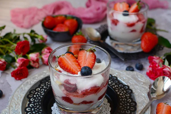 Großaufnahme-Glas mit köstlichem Quark-Dessert mit Erdbeeren und Blaubeeren auf Metallteller vor grauem Hintergrund — Stockfoto