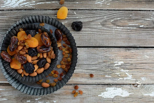 Layout of dried fruits - prunes, dates, raisins, dried apricots and nuts on a gray background. Top view, copy space