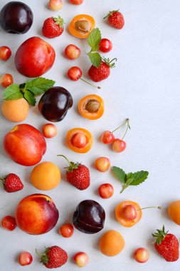 Renkli meyve ve meyvelerin yaratıcı bileşimi - çilek, şeftali, kiraz, kayısı, kayısı, beyaz arka planda erik, üst manzara, düz yatış.