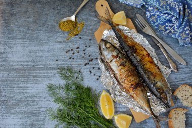 Grilled fish with lemon and spices on a blue background. Layout, copy space. View from above