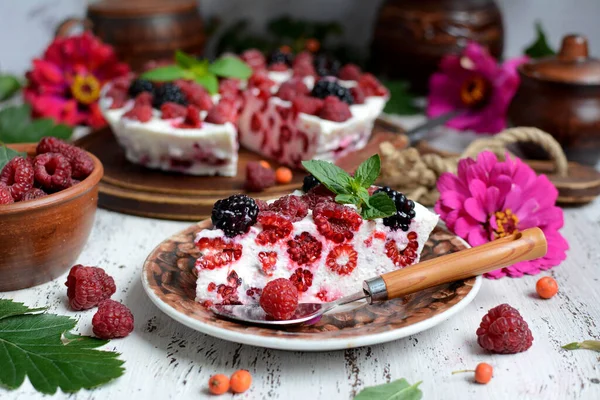 Κοντινό πλάνο ενός ορεκτικού κομματιού κέικ τυρόπηγμα με σμέουρα σε φόντο από φωτεινά λουλούδια. Εποχιακή κουζίνα — Φωτογραφία Αρχείου