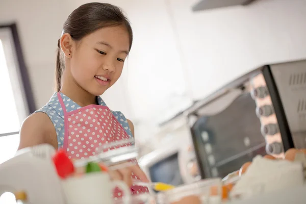 Weinig Aziatische schattig chef-kok koken een bakkerij in keuken — Stockfoto