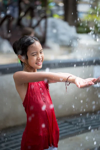 Asiática chica jugando con agua fuente en agua parque — Foto de Stock